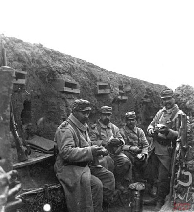 Soldiers sit down for a meal in the trench.