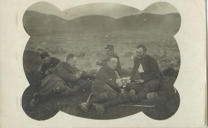 Soldiers at rest--eating, smoking and playing cards.