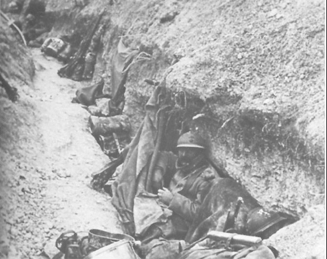 Typical shelters dug into the walls of a trench with a tent canvas strung up for cover.