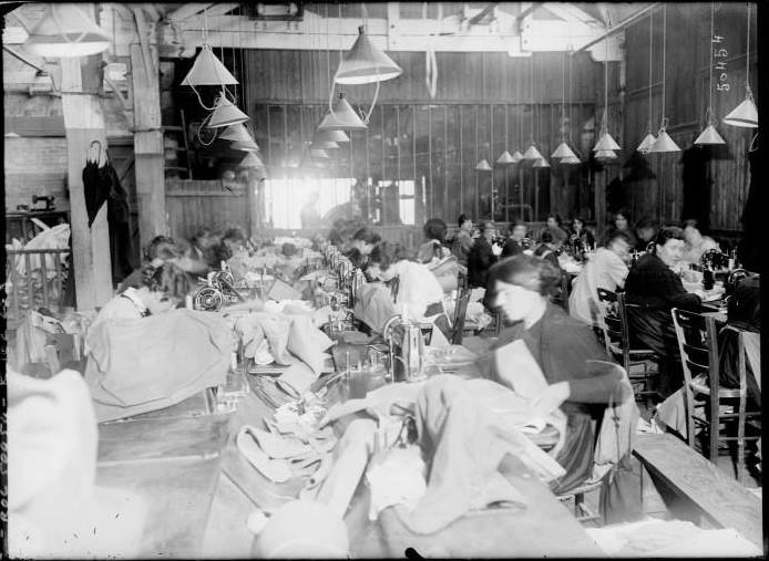 Civilians working on uniforms. 