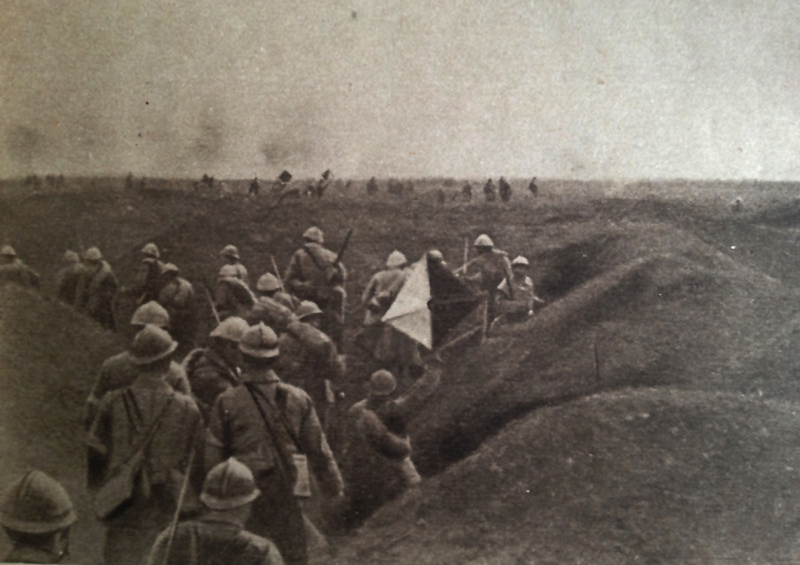 Photo taken during the assault on Dompierre (Somme) 1 July 1916. The second wave waits in a trench with the first waves visible in the distance. The man on the right holds a semaphore and additional signal men can be seen in the distance marking the progr