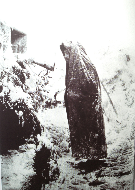 A sentinel stands watch at a loop-hole in the mountainous Vosges region (La Fontenelle). Photo taken by Frantz Adam, 1915.