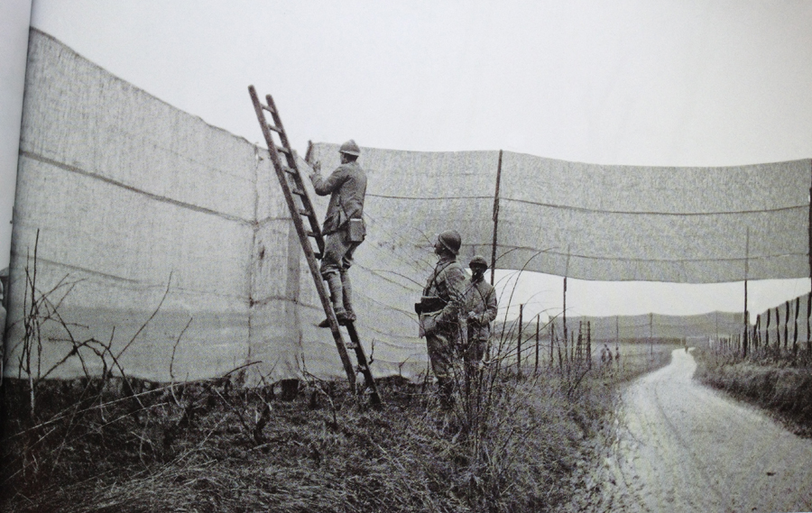 Canvas netting is erected along a roadway to prevent aerial observation as part of the preparations of the Chemin-des-Dames offensive. Photo taken by Frantz Adam, near Villers-Franqueux, March 1917.