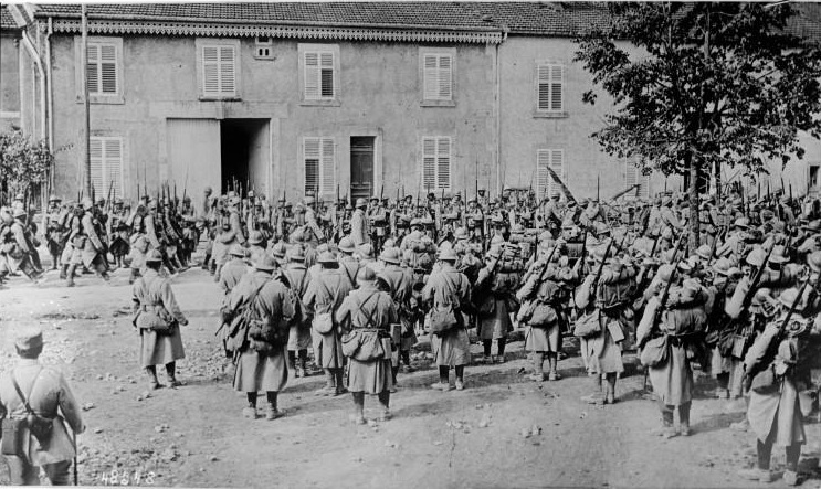 A regimental band plays for a passing column of troops.