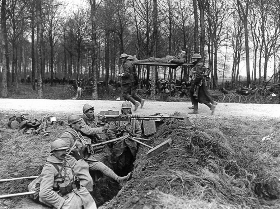 A group of American stretcher-bearers pass by a French MS emplacement in 1918.