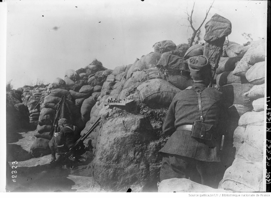 A zouave looks out of a camouflaged periscope.