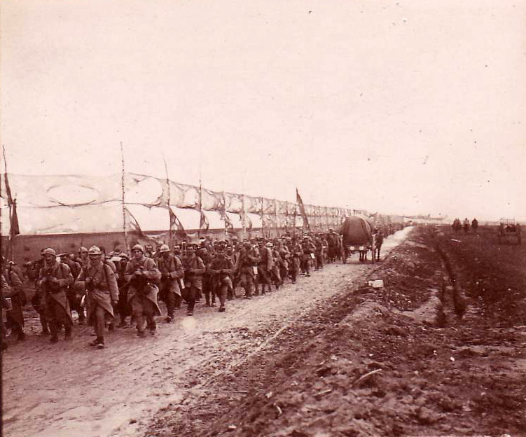 A regiment marched along a road camouflaged be canvas screens near Glennes.