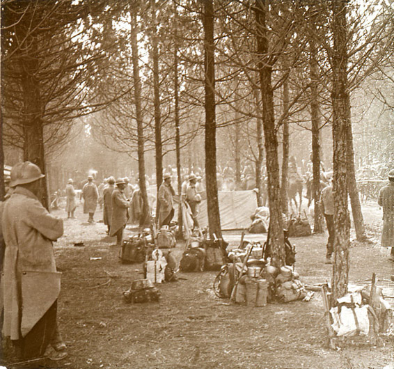 An infantry regiment, packs stacked together, watch cavalry move by.