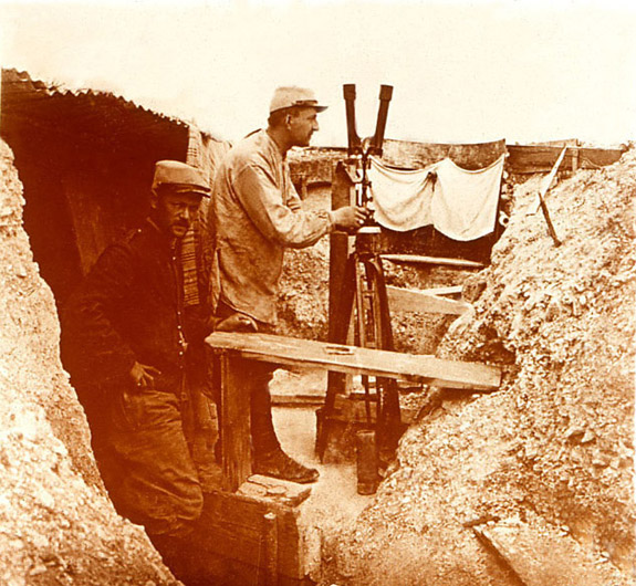 A soldier uses a periscope to view the enemy's lines, 1915.