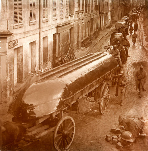 Engineers roll through a town with pontoons.