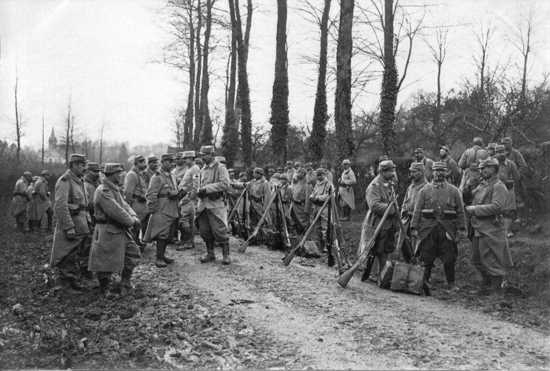 A column makes a brief halt during a march, 1915.