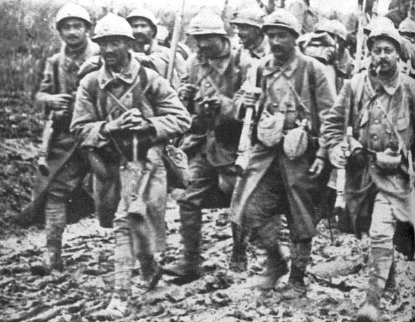 Soldiers coming out of Verdun, 1916. Note the soldiers carrying a German stick grenade and canteen.