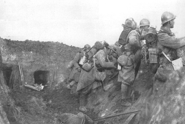 Soldiers man the parapet of a recently conquered trench amid debris and a German corpse.