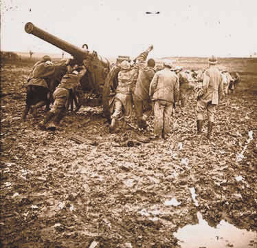 Artillerists struggle through the mud to haul up their gun, a 120 'long.'
