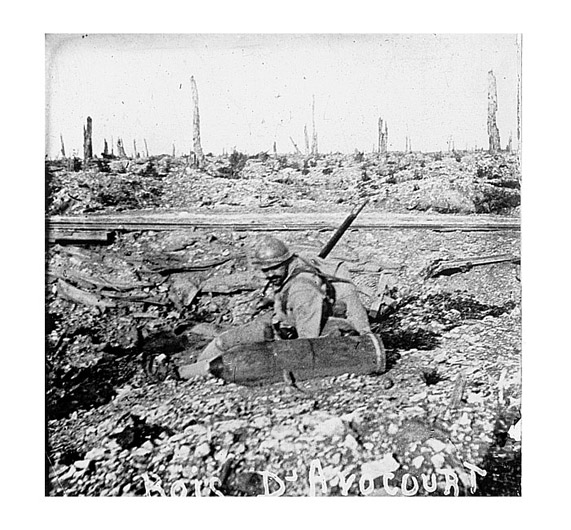 A soldier takes a close look at an unexploded heavy shell in Bois d'Avaucourt, Verdun.