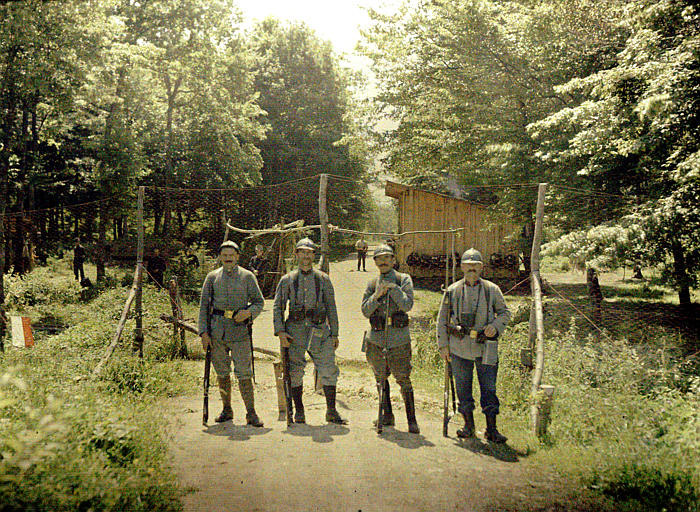 A group of territorials stand guard at the entrance to a barracks camp.