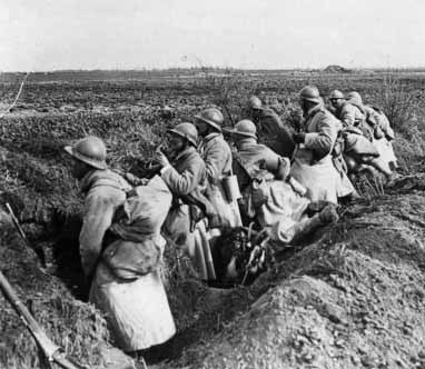 A squad occupies their freshly dug fox-holes along a roadside, Somme, 1918.