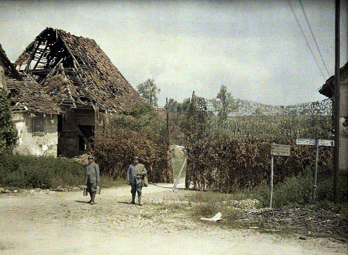 Ration men passing through a devastated village.