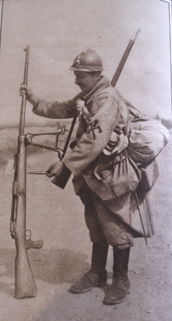 A soldier stands beside a large-caliber rifle, probably an anti-armor gun.