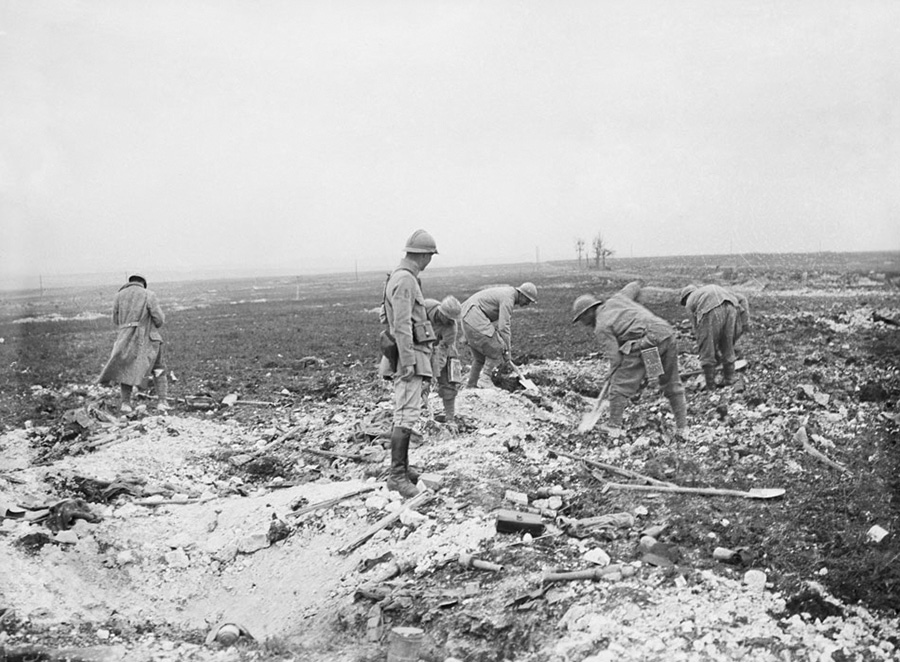 A post-war shot showing soldiers filling in the trenches with earth and debris.