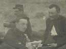 Soldiers at rest--eating, smoking and playing cards.