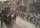 A column of French infantry marches past a group of British troops. 