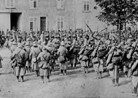 A regimental band plays for a passing column of troops.