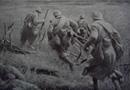 A group of soldiers dashes through a gap in the French wire.