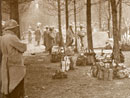 An infantry regiment, packs stacked together, watch cavalry move by.