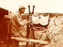 A soldier uses a periscope to view the enemy's lines, 1915.