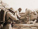 Soldiers quickly putting on their gas masks. Note the man on the left carrying a flame-thrower.