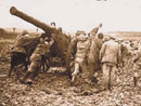 Artillerists struggle through the mud to haul up their gun, a 120 'long.'