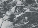 A mixed force of British and French soldiers sits in freshly dug fox-holes, Somme, 1918.