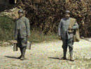 Ration men passing through a devastated village.