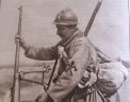 A soldier stands beside a large-caliber rifle, probably an anti-armor gun.