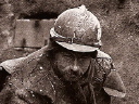 An engineer shovels mud out of a trench, Nieuport 1915.