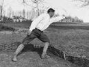 An instructor demonstrates the correct aiming position taken before lobbing a grenade.