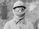 An anonymous soldier dons a P2 gas mask and goggles. (1915)