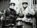 A group of soldiers donning TN gas masks and sheepskins presents a truly strange sight. An incredible juxtaposition of antiquity and modernity. The men have written their names in chalk to identify themselves. (Dec. 1915)