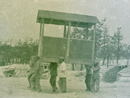 Men on a crap detail -- moving a portable latrine at camp.