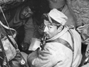 A soldier reads a letter at the entrance to an underground shelter in Champagne.