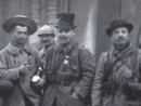 Soldiers requisition a set of fine hats in an abandoned village. One, lacking anything finer, is even wearing a hat box.