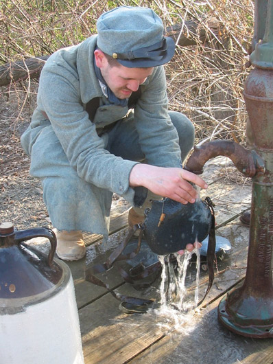 Sdt. Schech fills canteens behind the lines, April 2005.