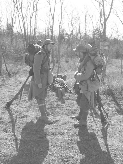 Sgt. Contamine and Sdt. Bracken, help off-set the weight of their packs by using their rifles to prop them up, April 2005.
