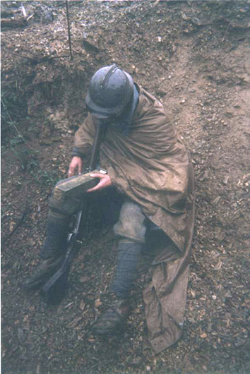 Sgt. Contamine cleans the mud and water from the mirrors of a periscope, April 2006