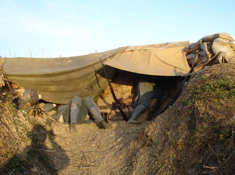 One man rests as another watches the enemy at the observation post, April 2007.