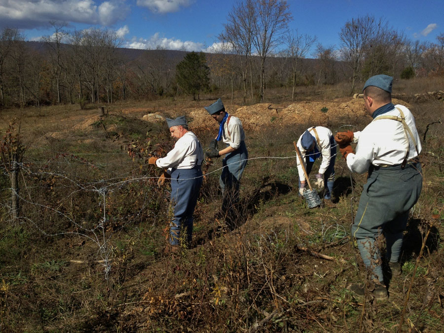 Members of the 151 setting up barbed-wire before the event begins. Newville, November 2013.