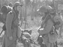 Sgt. Contamine and Sdt. Bracken, help off-set the weight of their packs by using their rifles to prop them up, April 2005.