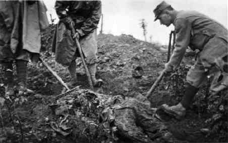 Soldiers exume the remains of the dead