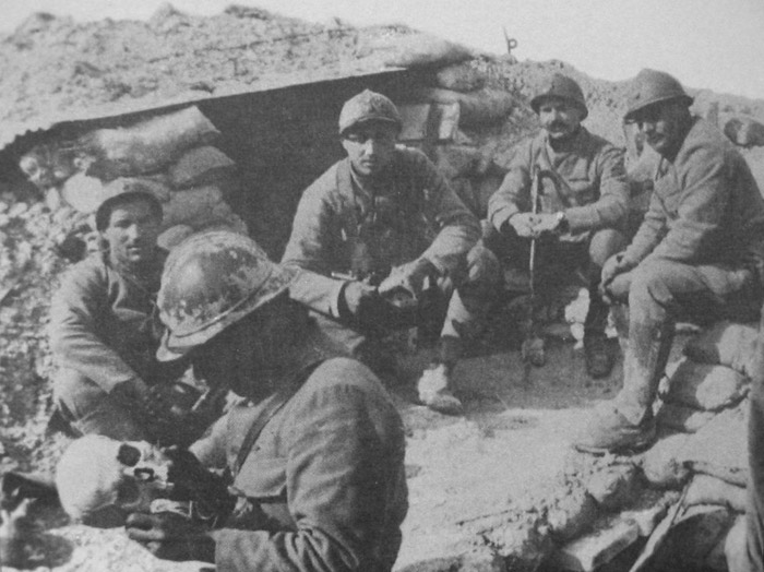 A soldier casually examines a skull.